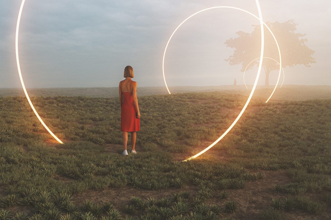 Tekst o założeniach i efektach psychologii analitycznej Junga. Na zdjęciu: Kobieta w czerwonej sukience stojąca na polu z świecącymi kręgami - HelloZdrowie