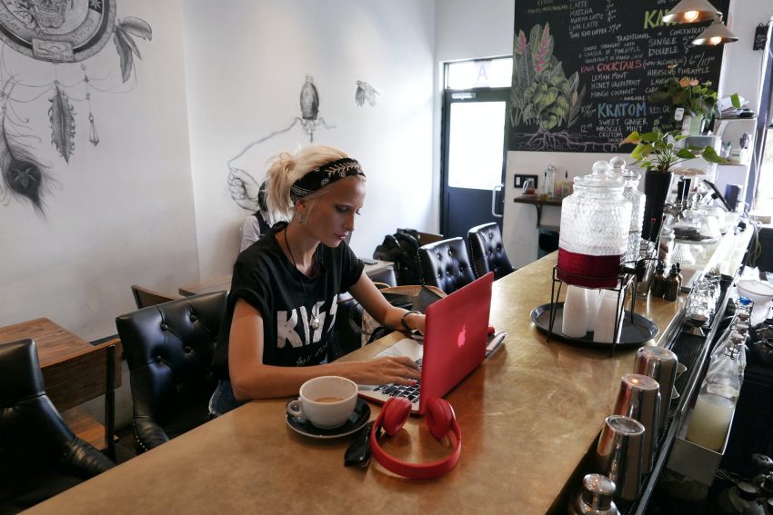 Kobieta pracuje na laptopie w kawiarni