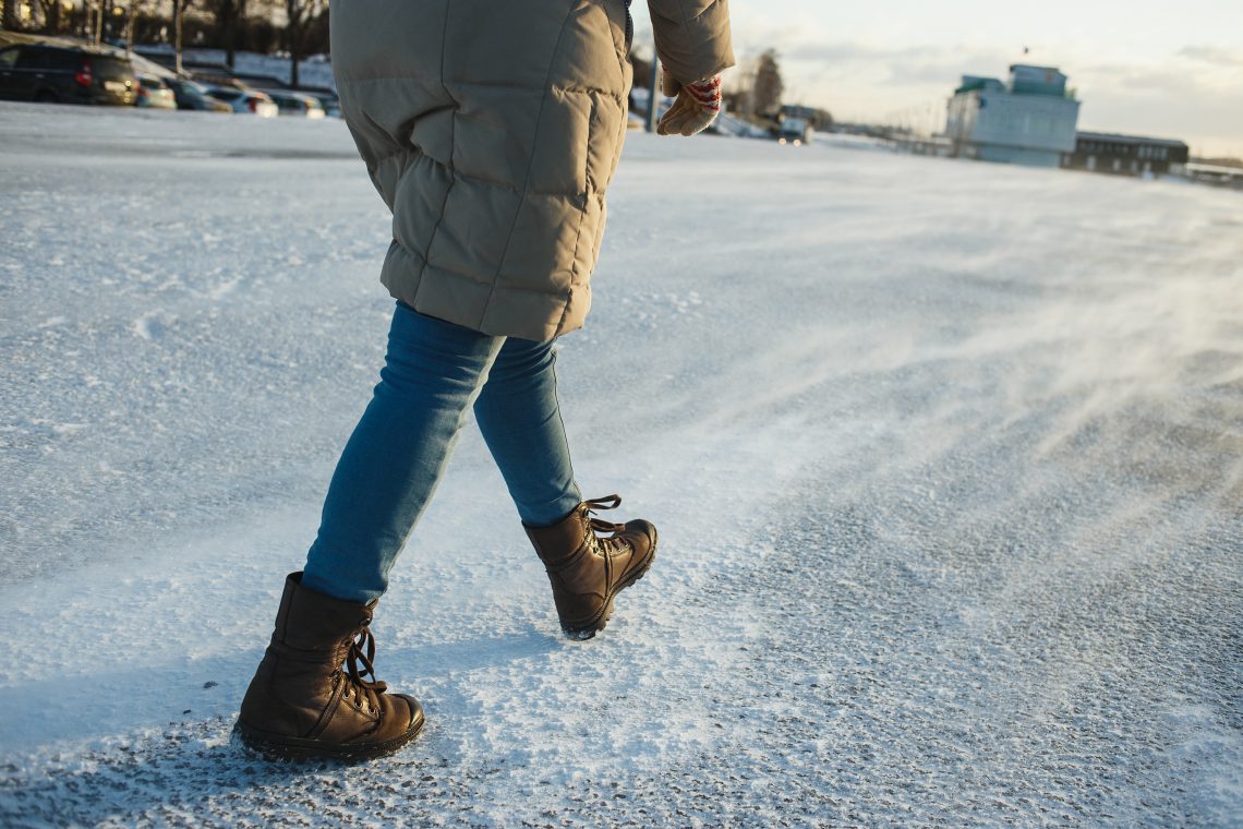 Tekst o zimowej pielęgnacji i ćwiczeniach dla stóp. Na zdjęciu: Osoba idąca po śniegu - HelloZdrowie