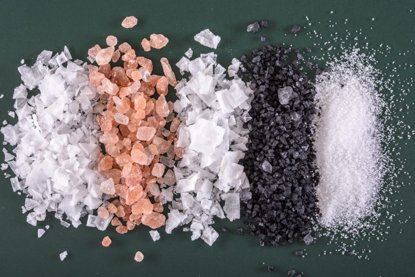 5 rodzajów soli rozsypanych na czarnym tle i ułożonych w grube paski obok siebie.