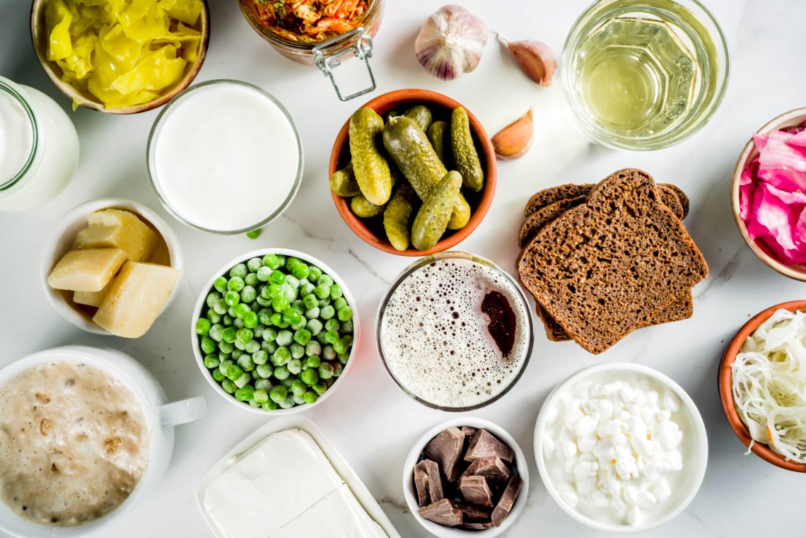 Tekst o korzyściach zdrowotnych wynikających z probiotyków. Na zdjęciu: Stół z różnymi jedzeniami - HelloZdrowie