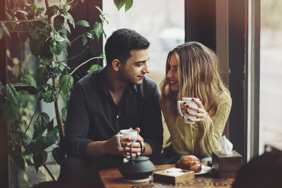 Tekst o rozpoczęciu rozmów o bezpiecznym seksie. Na zdjęciu: Mężczyzna i kobieta siedzą przy stole z filiżankami kawy - HelloZdrowie