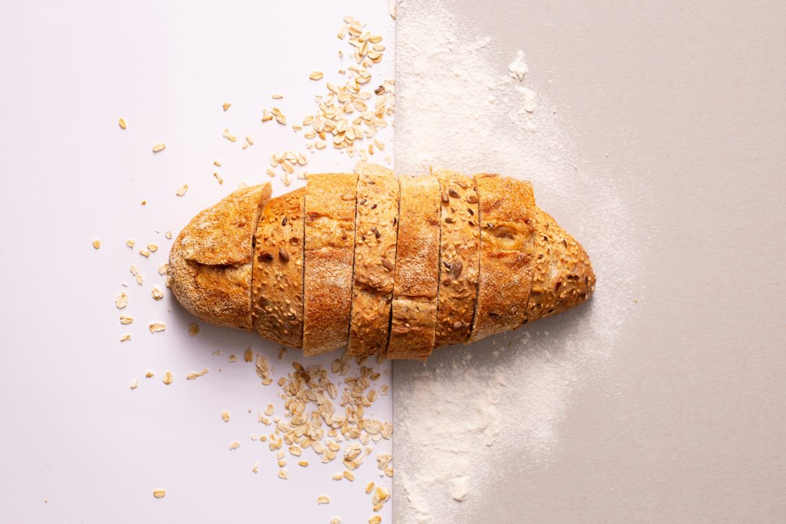 Tekst o właściwym wyborze naturalnego chleba. Na zdjęciu: Bochenek chleba na stole - HelloZdrowie