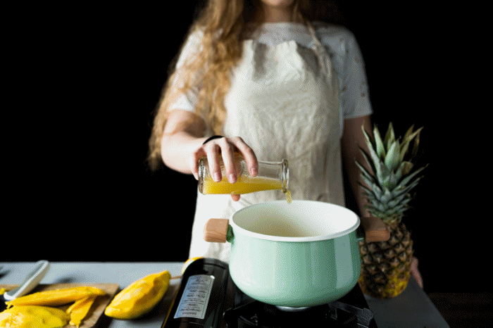 kobieta wlewająca sok z ananasa