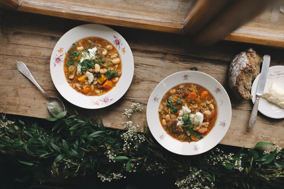 Tekst o ribollicie, włoskiej zupie z warzyw i chleba. Na zdjęciu: Dwie talerze z zupą na stole - HelloZdrowie