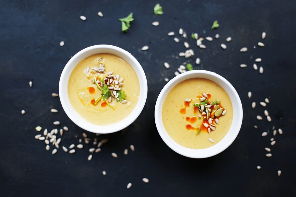 Tekst o rozgrzewającej zupie z soczewicy na zimę. Na zdjęciu: Dwie miski zupy z nasionami na wierzchu - HelloZdrowie