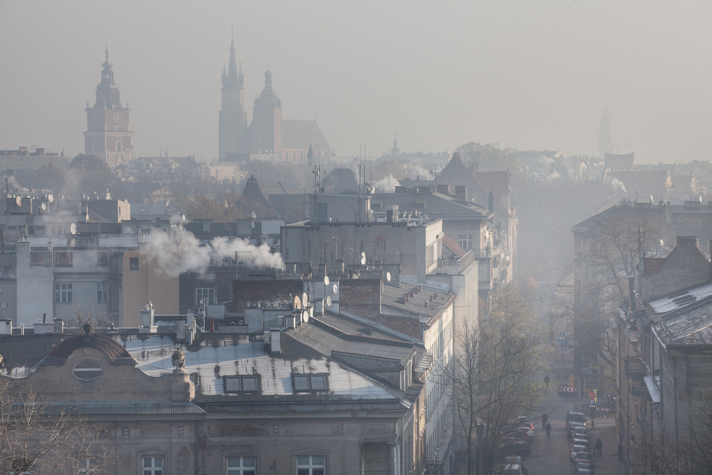 Tekst o przetrwaniu w sezonie smogowym i ochronie zdrowia. Na zdjęciu: Miasto z wieloma budynkami i dymem wydobywającym się z niego - HelloZdrowie