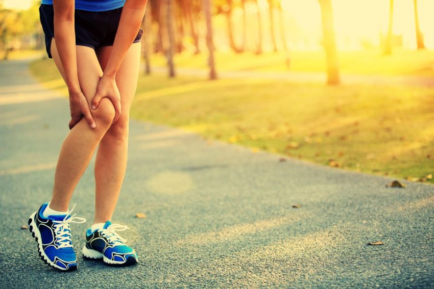 Biegacz trzyma się za bolące z tyłu kolano