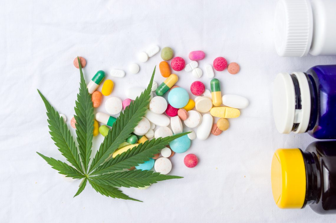 Tekst o mitach dotyczących leczenia raka marihuaną. Na zdjęciu: Zielony liść obok tabletek - HelloZdrowie