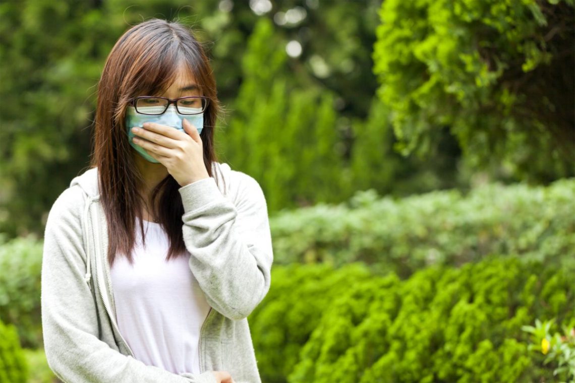 Kobieta zasłania usta z powodu świńskiej grypy