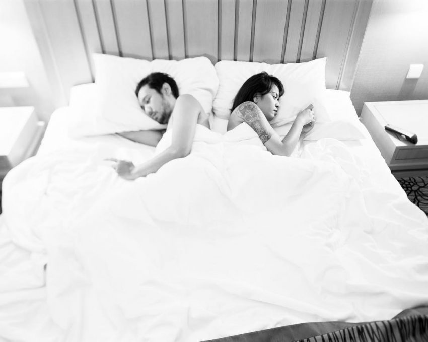Tekst o uzależnieniu od telefonów komórkowych. Na zdjęciu: Mężczyzna i kobieta leżący w łóżku - HelloZdrowie