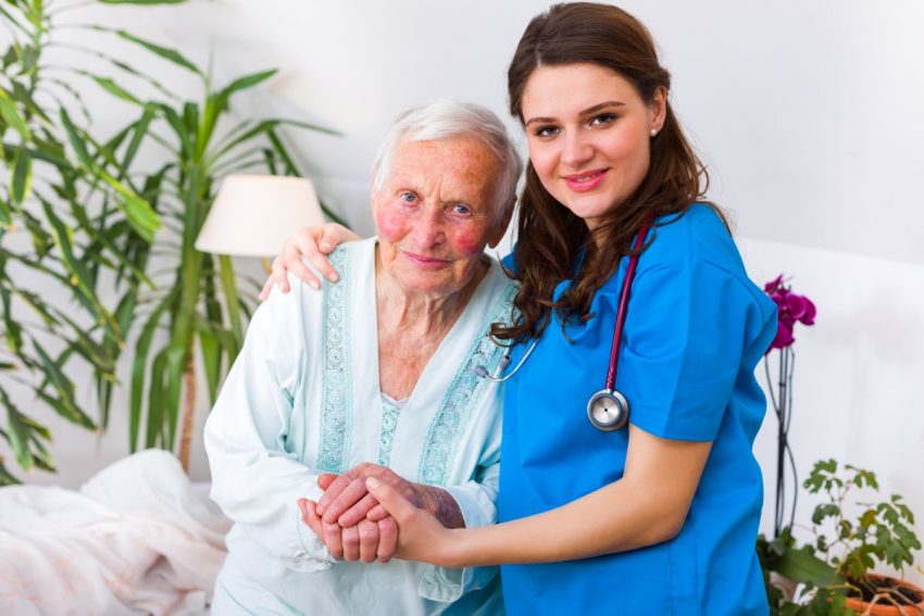 Starsza kobieta z chorobą Parkinsona w towarzystwie pielęgniarki