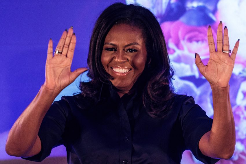 Michelle Obama uśmiecha się i podnosi ręce
