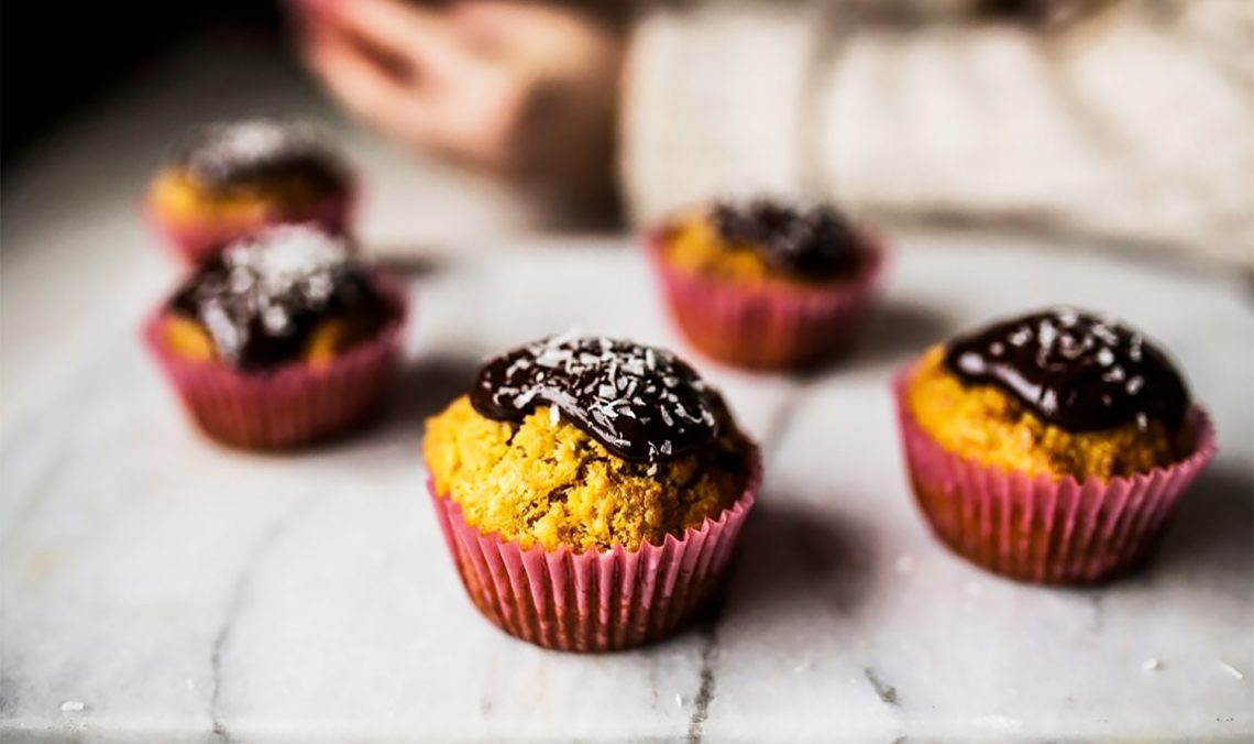 Tekst o wegańskich muffinach marchewkowo-pomarańczowych bez cukru. Na zdjęciu: Grupa muffinów z czekoladowym posypką - HelloZdrowie
