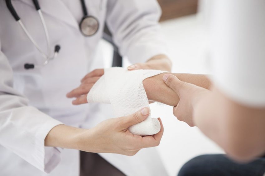 oparzenia - lekarz zakłada opatrunek na rękę