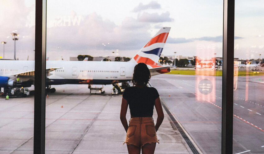 Jet lag, czyli zespół nagłej zmiany strefy czasowej; na zdjęciu kobieta na lotnisku- Hello Zdrowie