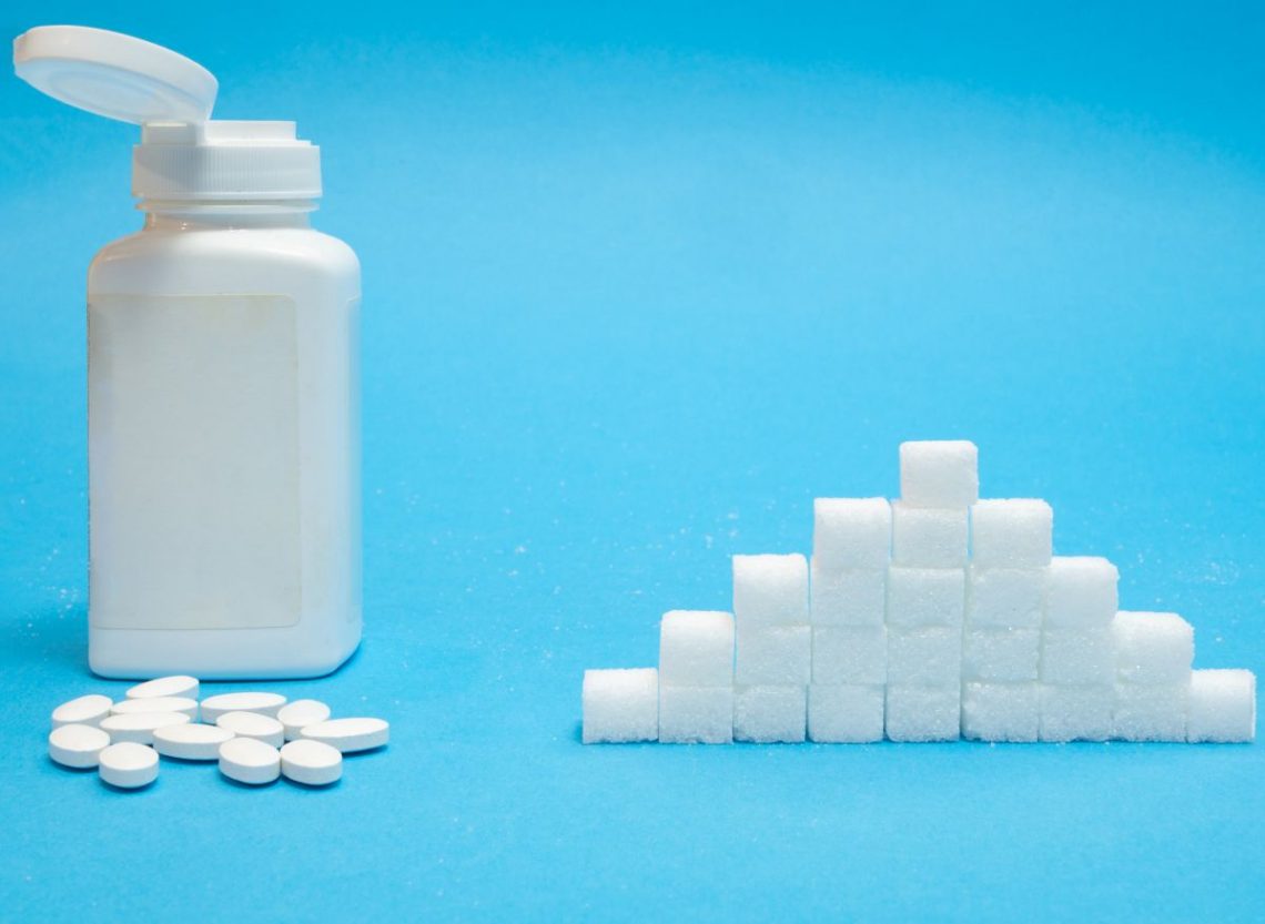 placebo - pudełko z tabletkami obok kostek cukru