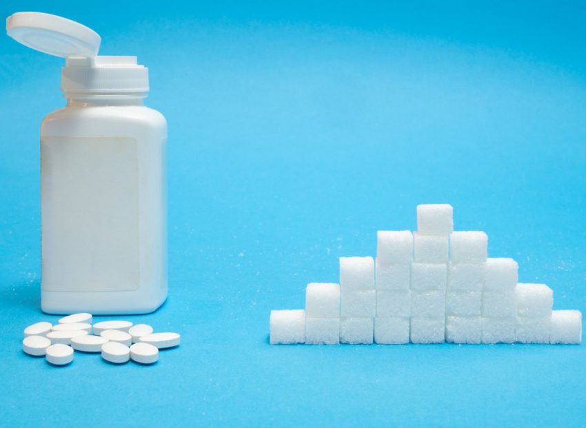 placebo - pudełko z tabletkami obok kostek cukru