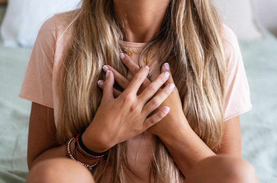 Grasiczak, czyli nowotwór grasicy. Czym się charakteryzuje?; na zdjęciu kobieta trzymająca dłonie na klatce piersiowej- Hello Zdrowie