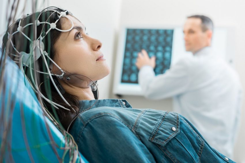 Kobieta leży w gabinecie lekarskim podłączona pod EEG