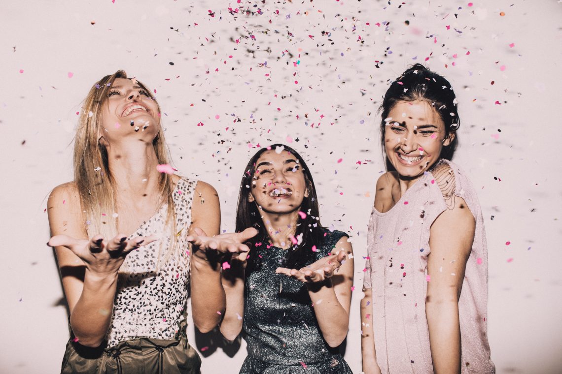 Tekst o Dniu Przyjaciółek celebrowanym 13 lutego. Na zdjęciu: Grupa kobiet rzucających konfetti - HelloZdrowie