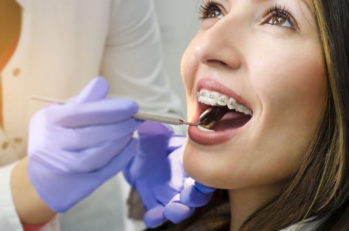 dentysta ogląda zęby młodej kobiety w gabinecie