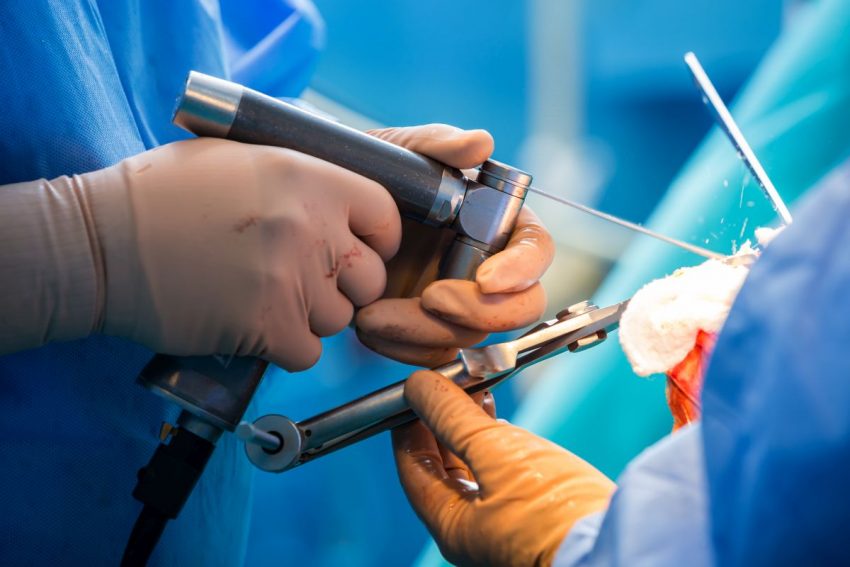 Dwóch lekarzy za pomocą przyrządów chirurgicznych wykonuje operację