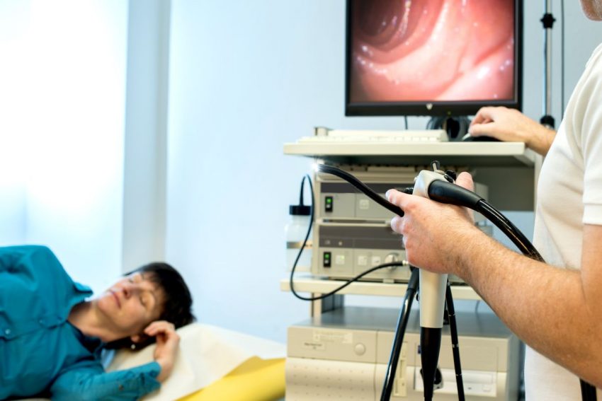 Mężczyzna leży na kozetce u lekarza, który wykonuje badanie za pomocą urządzenia