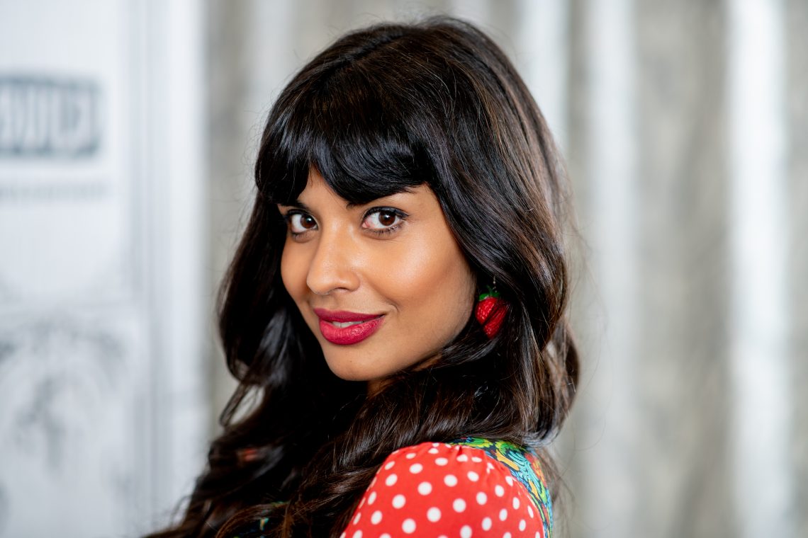 Tekst o Jameeli Jamil i jej walce z kulturą diety. Na zdjęciu: Kobieta z długimi włosami nosząca czerwoną szminkę i sukienkę w groszki - HelloZdrowie