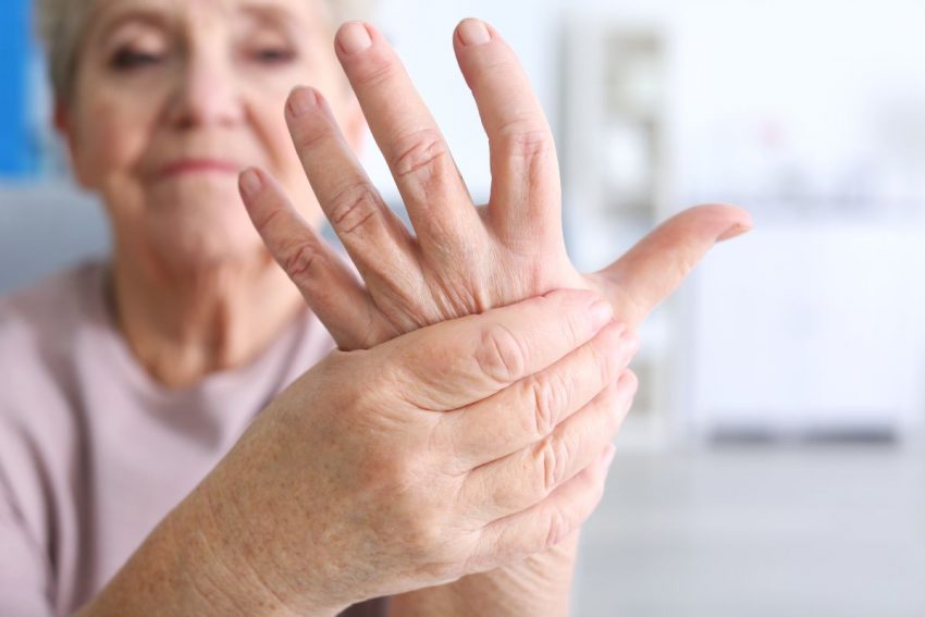 Starsza kobieta trzyma się za dłonie