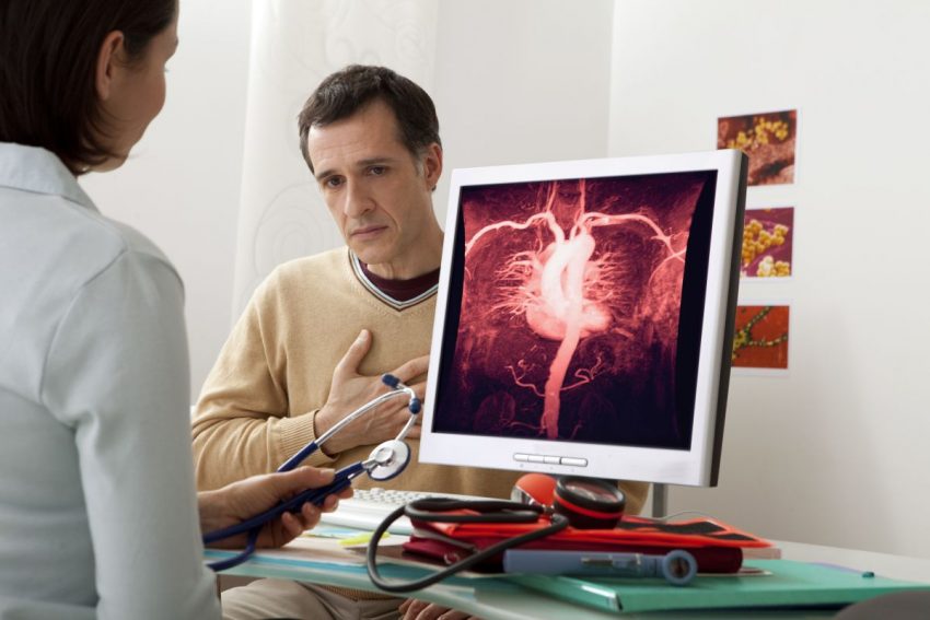 Lekarz pokazuje pacjentowi na ekranie jego problemy z aortą