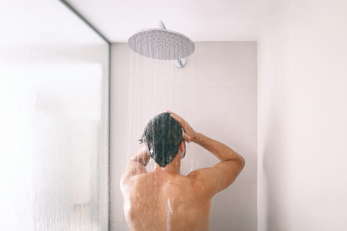 Na zdjęciu: mężczyzna myje się pod prysznicem, tekst o: liszaju twardzinowym napletka /fot. Adobe Stock