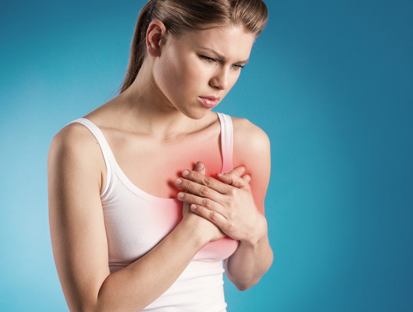 Kobieta z migotaniem komór trzyma się za klatkę piersiową.