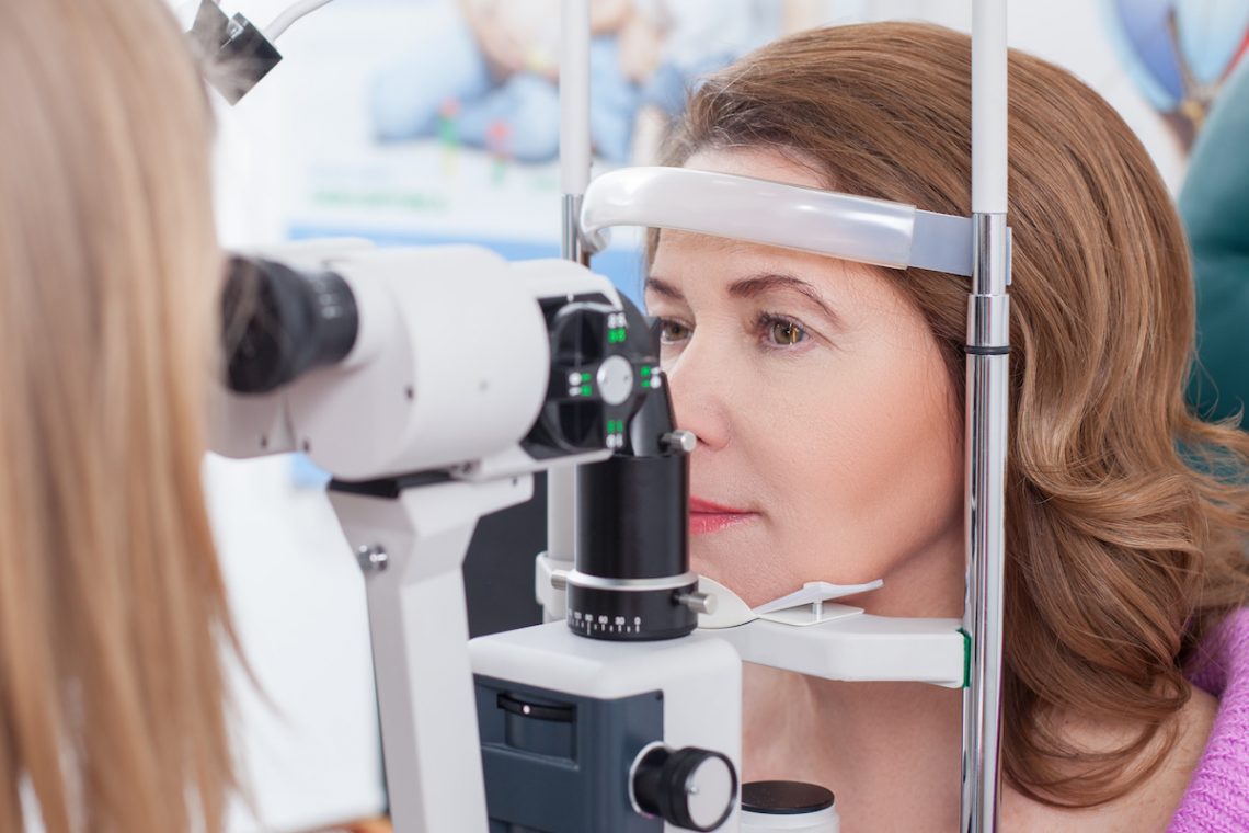 Kobieta z przekrwionymi oczami podczas badania okulistycznego.