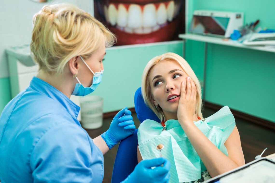 Kobieta z suchym zębodołem podczas wizyty u dentysty.