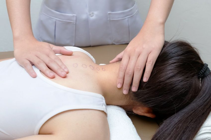 Kobieta cierpiąca na kifozę piersiową na masażu
