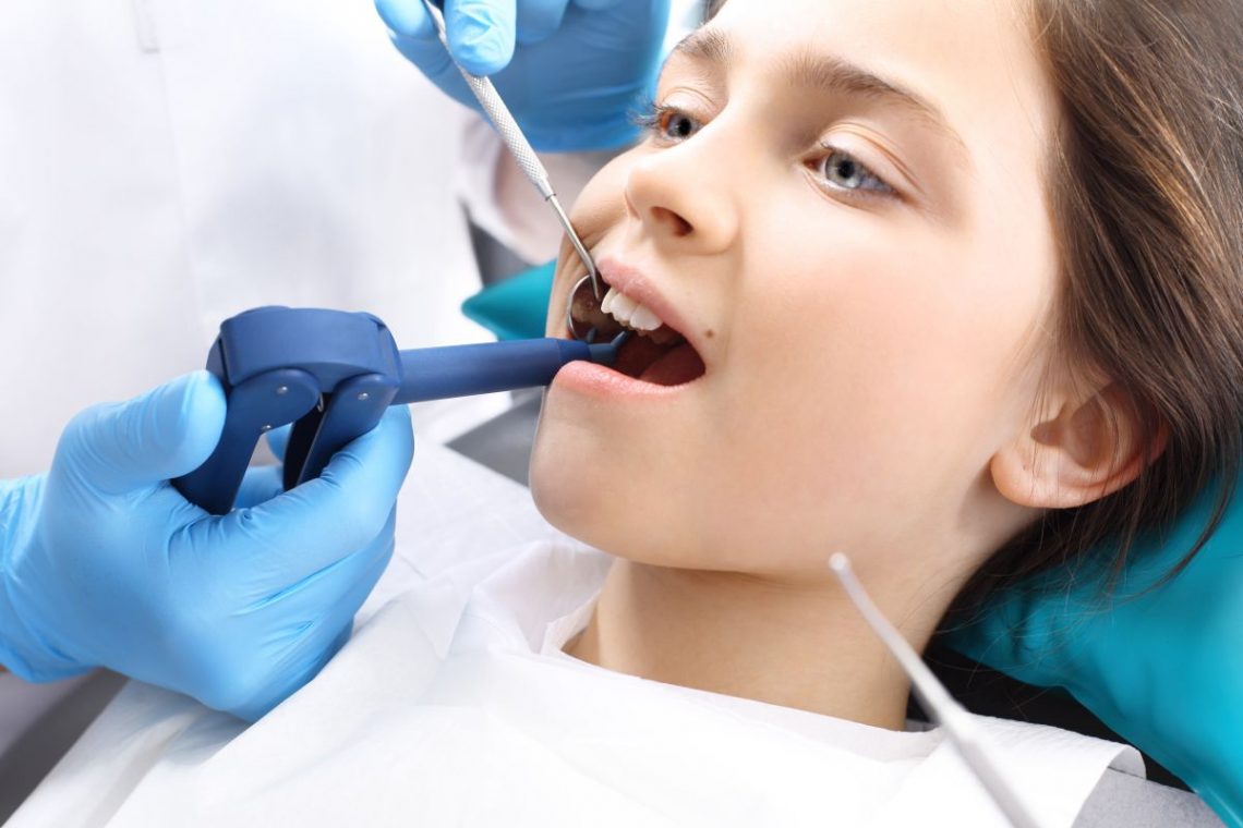 Dziewczynka u dentysty na zabiegu lakowania zębów