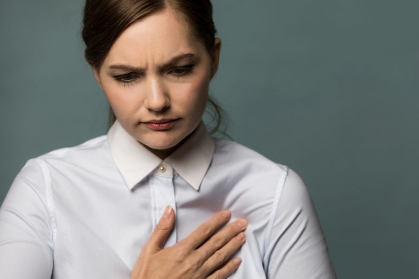kobieta kładzie rękę na klatce piersiowej z powodu bólu wywołanego sercem płucnym