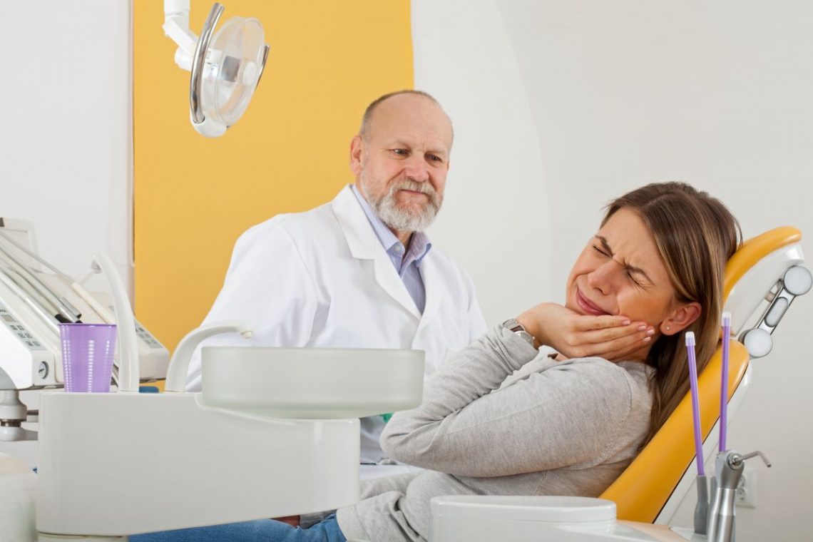 Kobieta będąca u dentysty, cierpiąca z powodu spuchniętego dziąsła