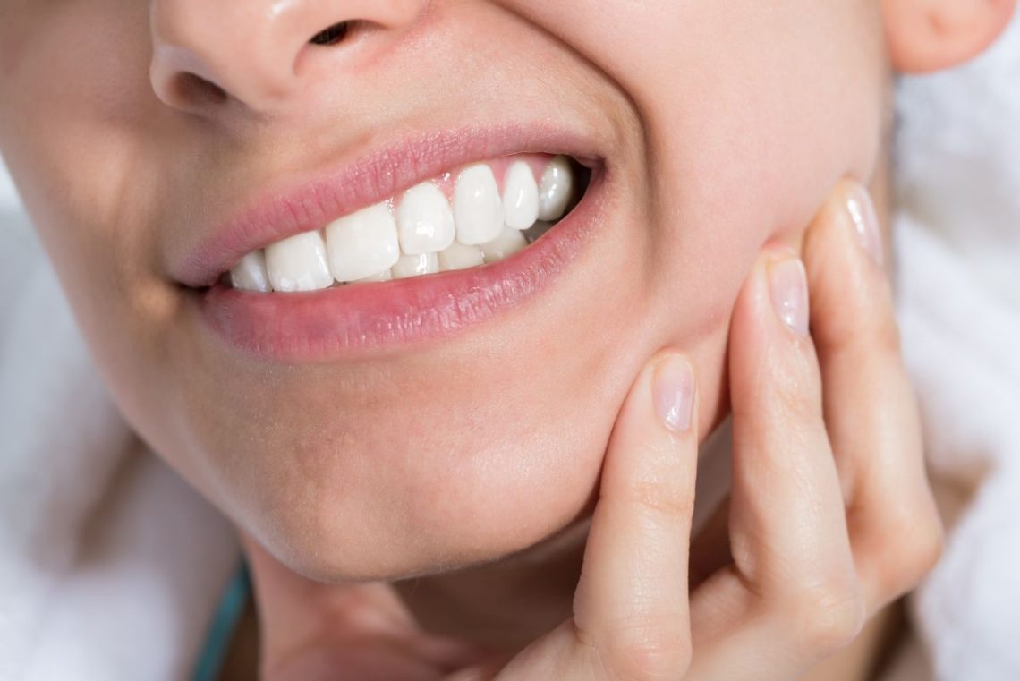 Kobieta z bolącymi zębami z powodu zgryzu otwartego