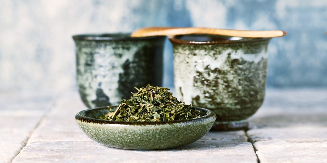 Tekst o wpływie zielonej herbaty na metabolizm. Na zdjęciu: Miska z liśćmi zielonej herbaty - HelloZdrowie