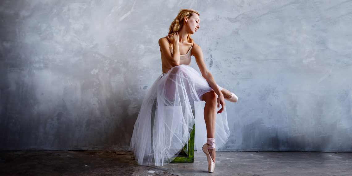 Tekst o wyzwaniach fizjoterapii tancerzy klasycznych baletu. Na zdjęciu: Kobieta w tutu i na tyczkach - HelloZdrowie