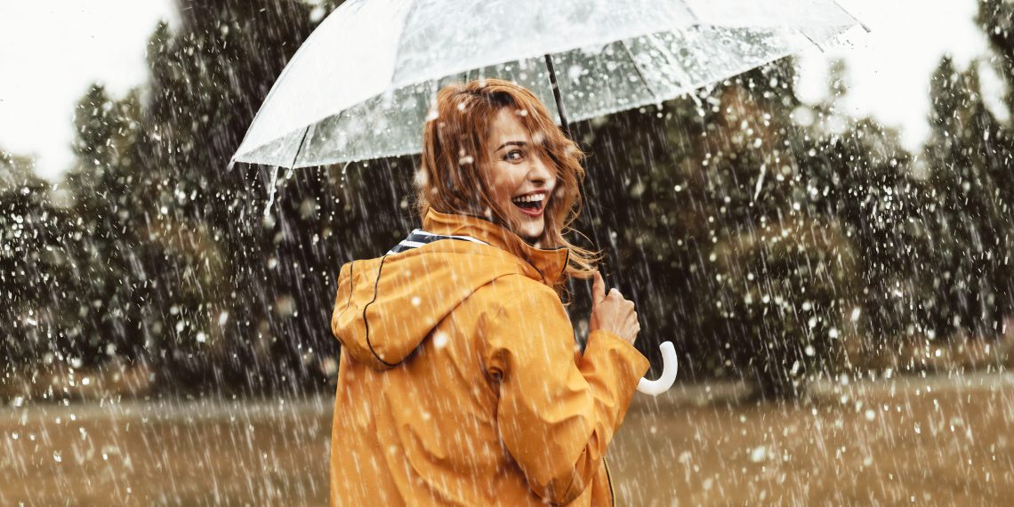 Tekst o wzmacnianiu odporności na sezon infekcyjny. Na zdjęciu: Kobieta trzymająca parasol podczas deszczu - HelloZdrowie