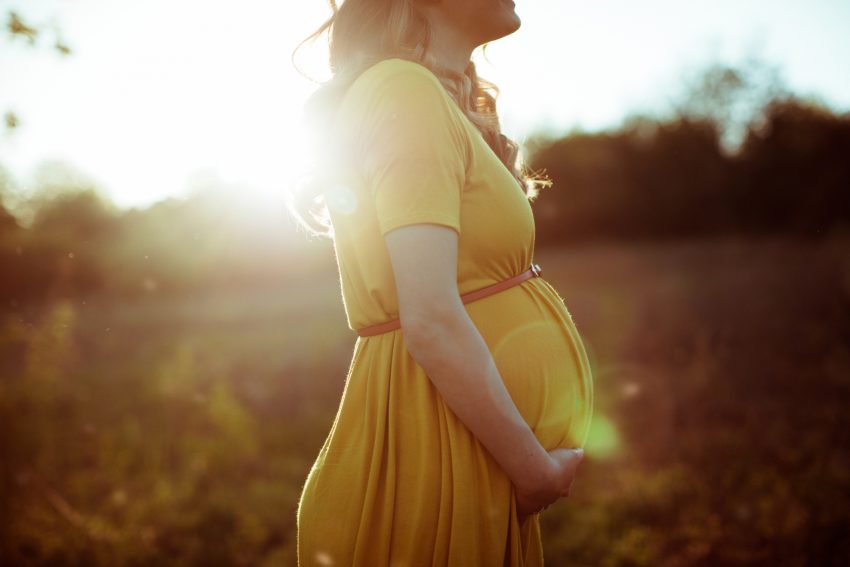 Kobieta w ciąży opala się na słońcu