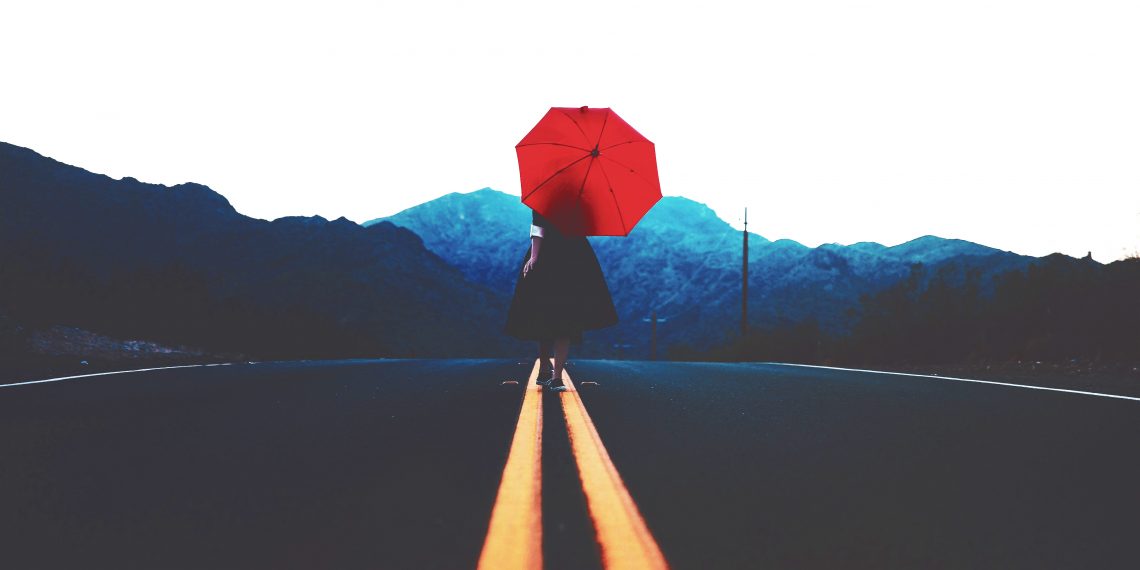 Tekst o faktach i mitach dotyczących odporności. Na zdjęciu: Osoba trzymająca parasol na drodze - HelloZdrowie