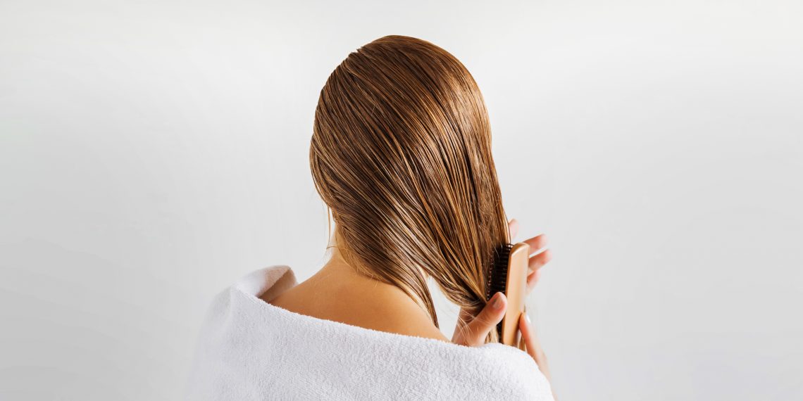 Tekst o mitach związanych z pienieniem się szamponu. Na zdjęciu: Kobieta czesząca swoje włosy - HelloZdrowie