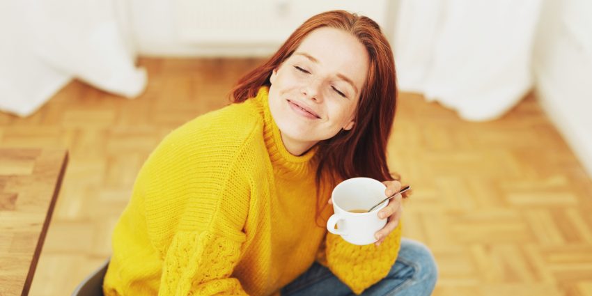 Uśmiechnięta kobieta z kubkiem herbaty