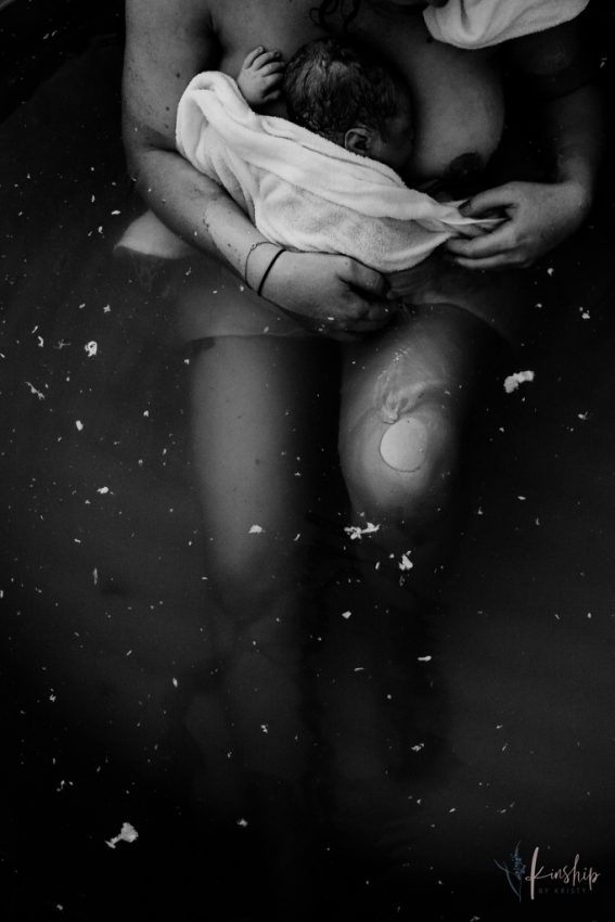 Tekst o konkursie fotografii porodowej i nagrodzonych zdjęciach. Na zdjęciu: Kobieta leżąca w wodzie z ręcznikiem - HelloZdrowie