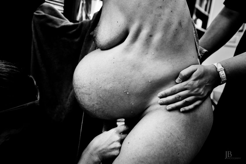 Tekst o konkursie fotografii porodowej i nagrodzonych zdjęciach. Na zdjęciu: Osoba trzymająca duży brzuch - HelloZdrowie