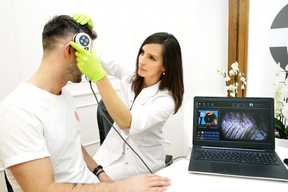 Tekst o męskiej higienie i pielęgnacji skóry. Na zdjęciu: Kobieta używająca urządzenia do sprawdzenia głowy mężczyzny - HelloZdrowie